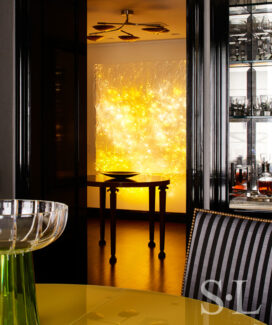 Fifth Avenue Pied-à-Terre view from dining table to foyer showing luminous wall sculpture by Astrid Krogh in bright yellow