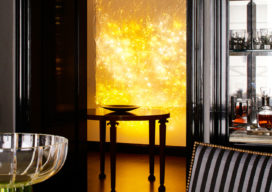 Fifth Avenue Pied-à-Terre view from dining table to foyer showing luminous wall sculpture by Astrid Krogh in bright yellow