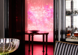 Fifth Avenue Pied-à-Terre view from dining table to foyer showing luminous wall sculpture by Astrid Krogh in hot pink