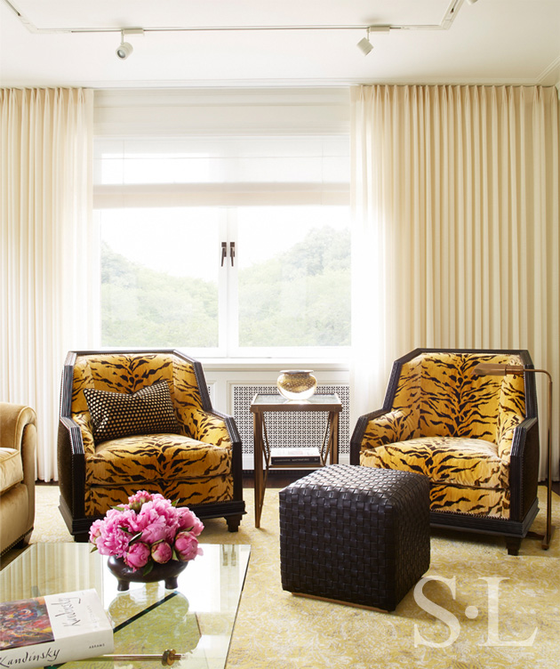 Living room seating detail with faceted armchairs with carved wood frame with animal print upholstery