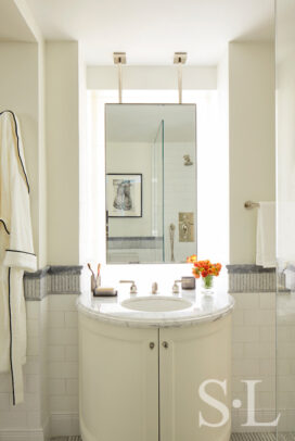 Fifth Avenue Pied-à-Terre bathroom in white and grey with a suspended vanity mirror and bow-front vanity