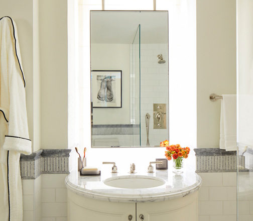 Fifth Avenue Pied-à-Terre bathroom in white and grey with a suspended vanity mirror and bow-front vanity
