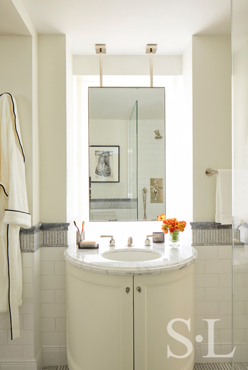 Fifth Avenue Pied-à-Terre bathroom in white and grey with a suspended vanity mirror and bow-front vanity