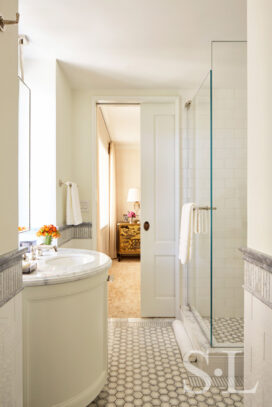 White and grey bathroom, view into bedroom through pocket door