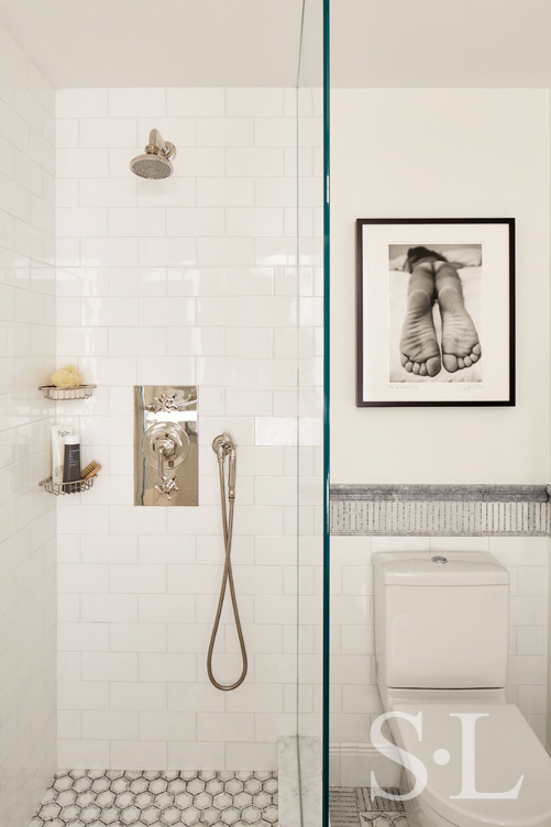 White and grey bathroom, view into shower with nickel hardware, and black and white photography