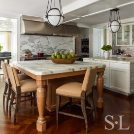 Chicago penthouse kitchen view of breakfast island with cerused-oak base and armchair-style barstools