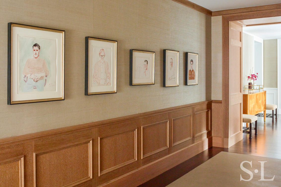 Chicago penthouse hallway with cerused oak paneled millwork and a collection of original artwork by David Hockney