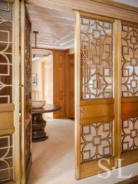 Chicago penthouse entry foyer view towards elevator and custom designed bronze and glass gates