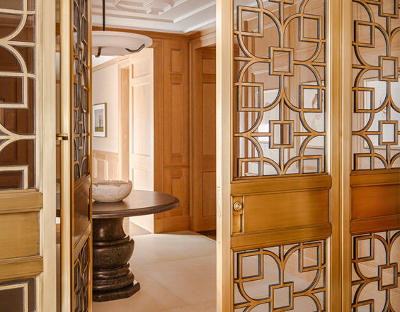 Chicago penthouse entry foyer view towards elevator and custom designed bronze and glass gates