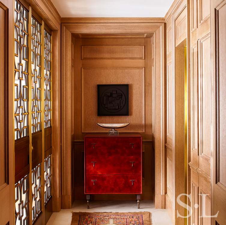 Chicago penthouse entry with limestone slab flooring, a cabinet made of leather and American black walnut, and artwork by Louise Nevelson