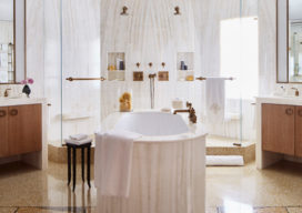 Master bath featuring onyx, cerused oak vanities and marble soaking tub