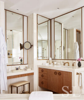 Master bath showing cantilevered cerused oak vanities and beveled bronze-framed mirrors