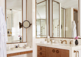 Master bath showing cantilevered cerused oak vanities and beveled bronze-framed mirrors