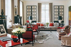 Deco-era duplex apartment living room in grey with red accents featuring a pair of wrought-iron French gates on the wall