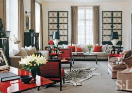 Deco-era duplex apartment living room in grey with red accents featuring a pair of wrought-iron French gates on the wall