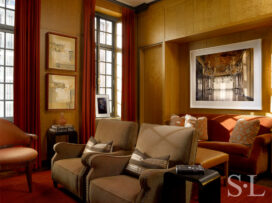 Deco-era duplex apartment media room with curly maple paneling, velvet sofa and artwork by Michael Eastman