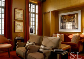 Deco-era duplex apartment media room with curly maple paneling, velvet sofa and artwork by Michael Eastman