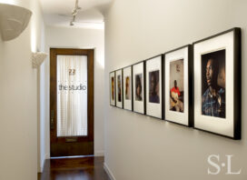 Deco-era duplex apartment hallway with photographs by Lee Friedlander