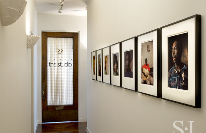 Deco-era duplex apartment hallway with photographs by Lee Friedlander