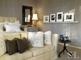 Deco-era duplex apartment primary bedroom with blue-gray upholstered walls and a picture rail with photos by Aaron Siskind