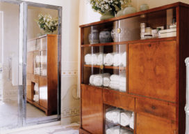 Deco-era duplex apartment bathroom detail showing large wood and glass storage cabinet