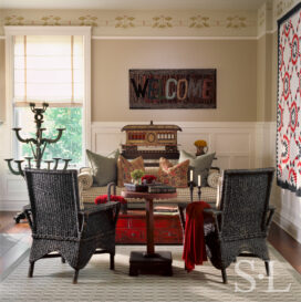 Restored landmark residence on former military base living room with ‘welcome’ hooked rug and handmade trolley – part of an old train set, and antique wicker chairs