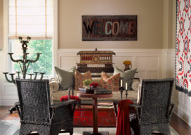 Restored landmark residence on former military base living room with ‘welcome’ hooked rug and handmade trolley – part of an old train set, and antique wicker chairs