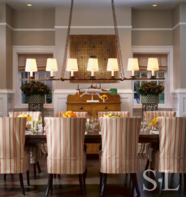 Restored landmark residence on former military base dining room with penny-pitch board on wall above a whirligig by Ed Larson