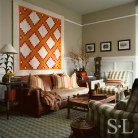 Restored landmark residence on former military base library seating area with a colorful Double Irish Chain quilt and photographs by Karl Blossfeldt