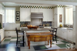 Restored landmark residence on former military base kitchen with green-and-white painted checkerboard floor and antique Irish butcher block table