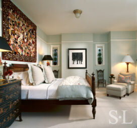 Restored landmark residence on former military base bedroom with antique wicker chairs and a Victorian crazy quilt above the bed