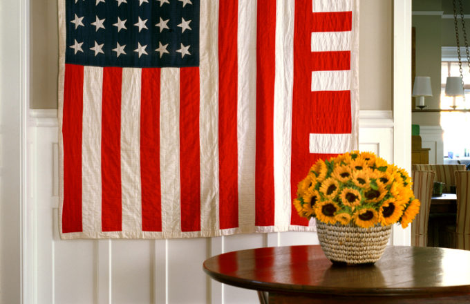 Restored landmark residence on former military base stair hall with table and chairs and a 1930’s “American Flag” quilt with improvised design