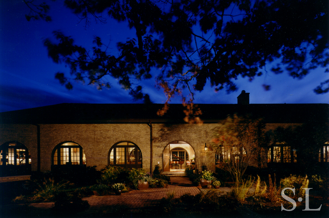 Front exterior at dusk of former artillery shed converted into luxury residence by Suzanne Lovell Inc.