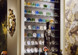 Chicago townhome entry detail with a bronze Kuan Yin statue and collection of Boston & Sandwich cup plates
