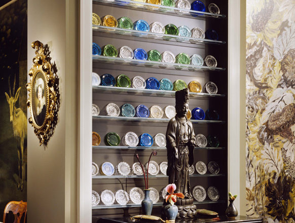 Chicago townhome entry detail with a bronze Kuan Yin statue and collection of Boston & Sandwich cup plates