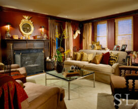 1920s era Lake Shore Drive penthouse library with red walls and round mirror above fireplace