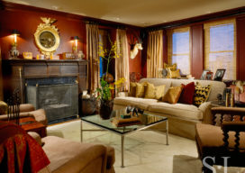 1920s era Lake Shore Drive penthouse library with red walls and round mirror above fireplace