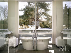 Lake house bathroom with soaking tub and view our large windows