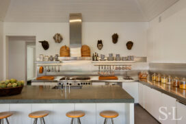 Contemporary kitchen in white, stainless steel and bluestone slate floors