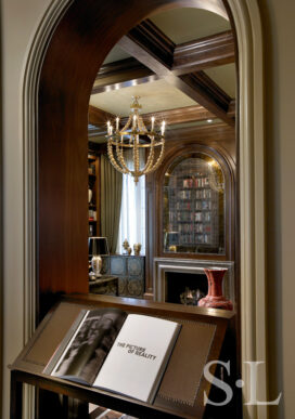 View into library through dark walnut-lined archway in Chicago Lincoln Park residence