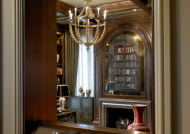 View into library through dark walnut-lined archway in Chicago Lincoln Park residence