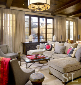 Casual seating area in family room with neutral upholstery and pops of red