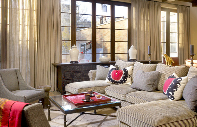 Casual seating area in family room with neutral upholstery and pops of red