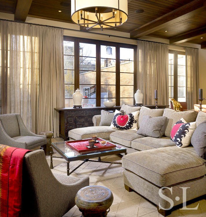 Casual seating area in family room with neutral upholstery and pops of red