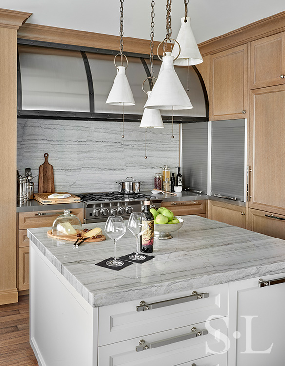 Chicago residence kitchen with light-colored rift-cut oak millwork, marble and stainless steel with ceramic pendant light fixture over center island