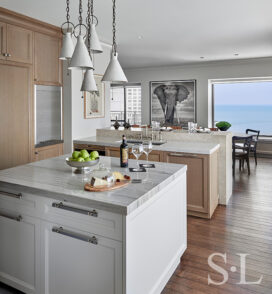 Chicago residence kitchen with light-colored rift-cut oak millwork, marble and stainless steel and view of Lake Michigan