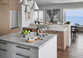 Chicago residence kitchen with light-colored rift-cut oak millwork, marble and stainless steel and view of Lake Michigan