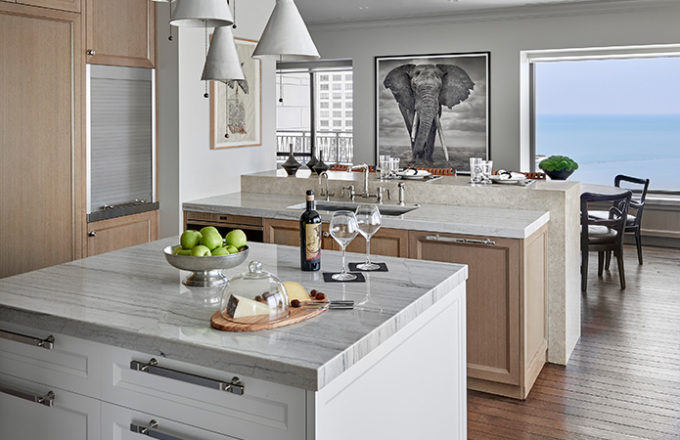 Chicago residence kitchen with light-colored rift-cut oak millwork, marble and stainless steel and view of Lake Michigan