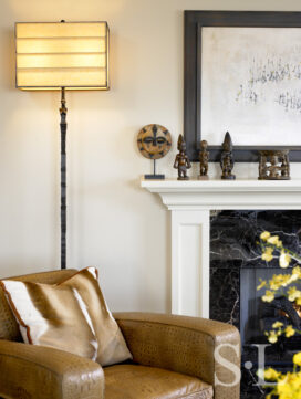 Chicago apartment living room fireplace seating detail with club chair upholstered in crocodile skin and lamp by Ingrid Donat