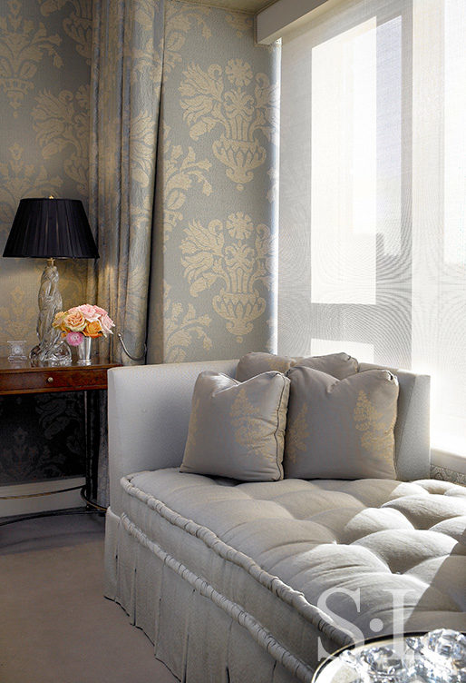 Chicago apartment bedroom with damask upholstered walls and drapery, and chaise in front of window